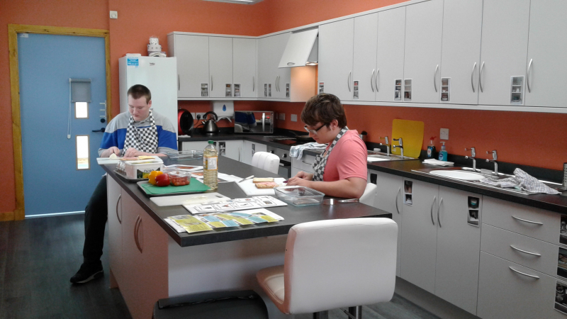 Two young people work in the brand new Life Skills Room at New Struan School