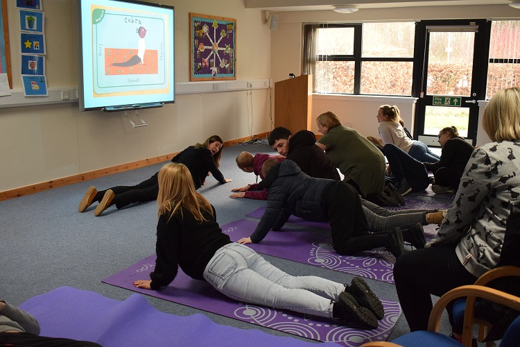 A group of pupils and staff doing yoga