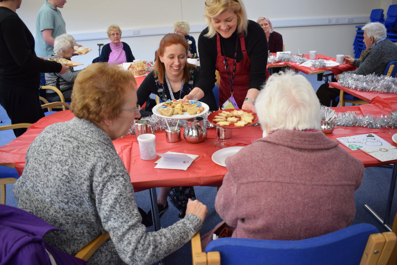 Serving cakes to ladies at the festive afternoon tea