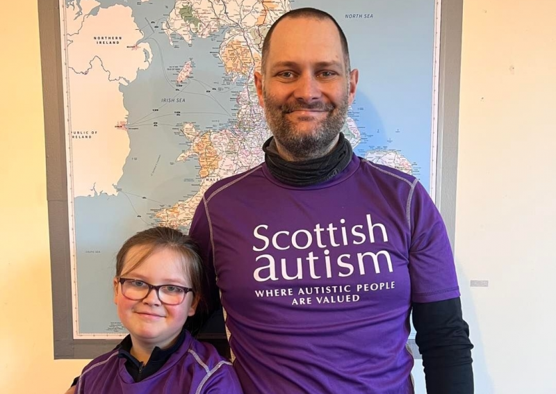 Adult and child wearing supporter tshirts, Scottish Autism, indoors