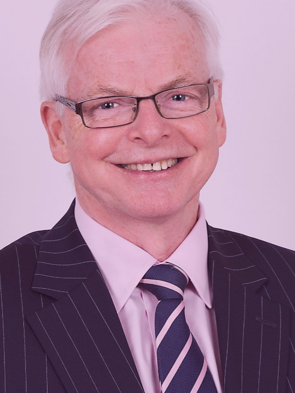 Man in suit smiles to the camera