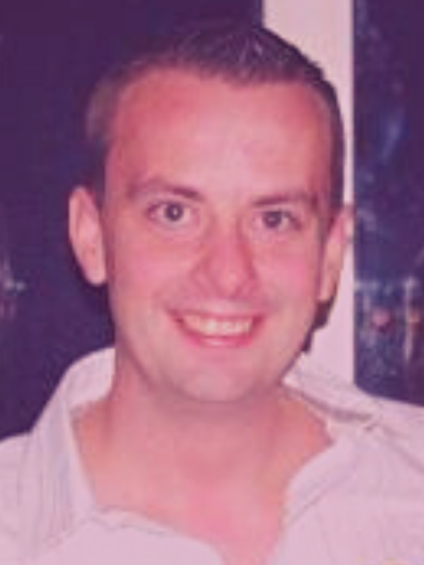 A man in a white tshirt smiles
