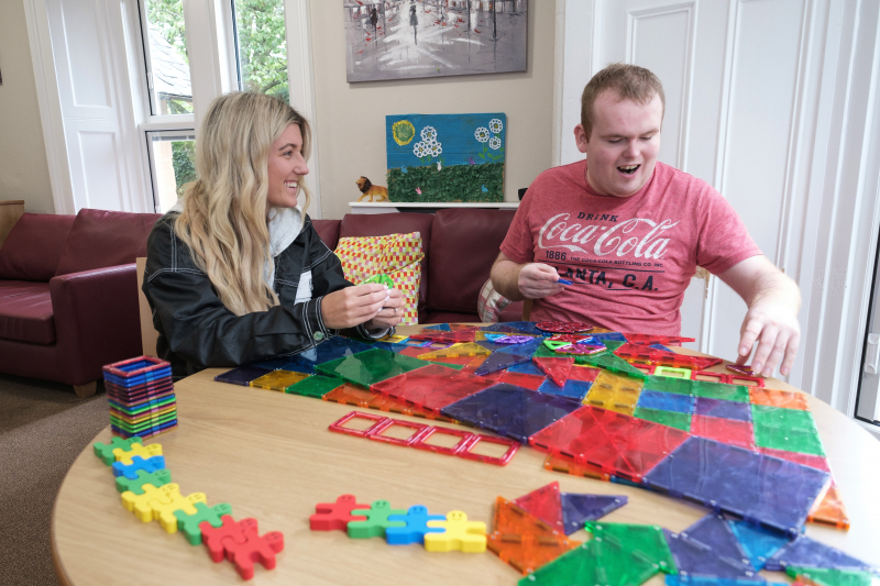 Two people playing with coloured shapes