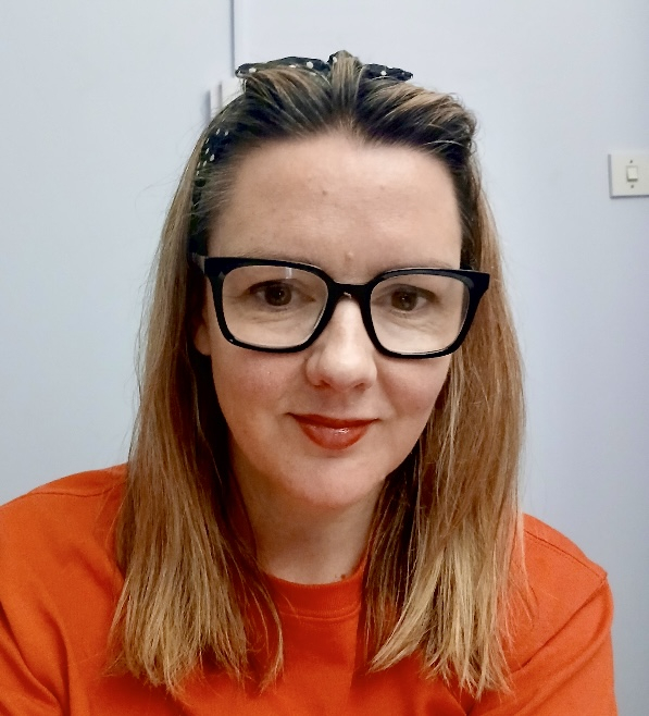 Image is of the group host, Fi Bailey, wearing an orange top
