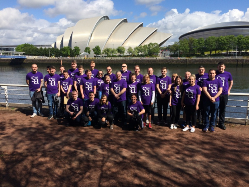 Group of supporters in Scottish Autism purple t-shirts, stand by the River Clyde with the SEC Armadillo in the background