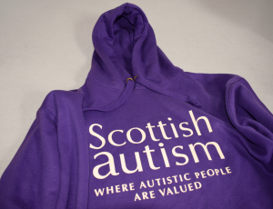 Purple hoodie jumper, Text reads 'Scottish Autism, Where autistic people are valued'