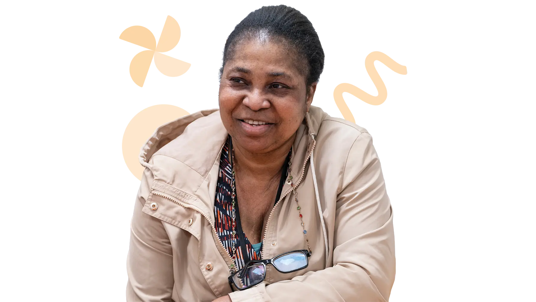 Image is of a person smiling while sitting with their arm on a table