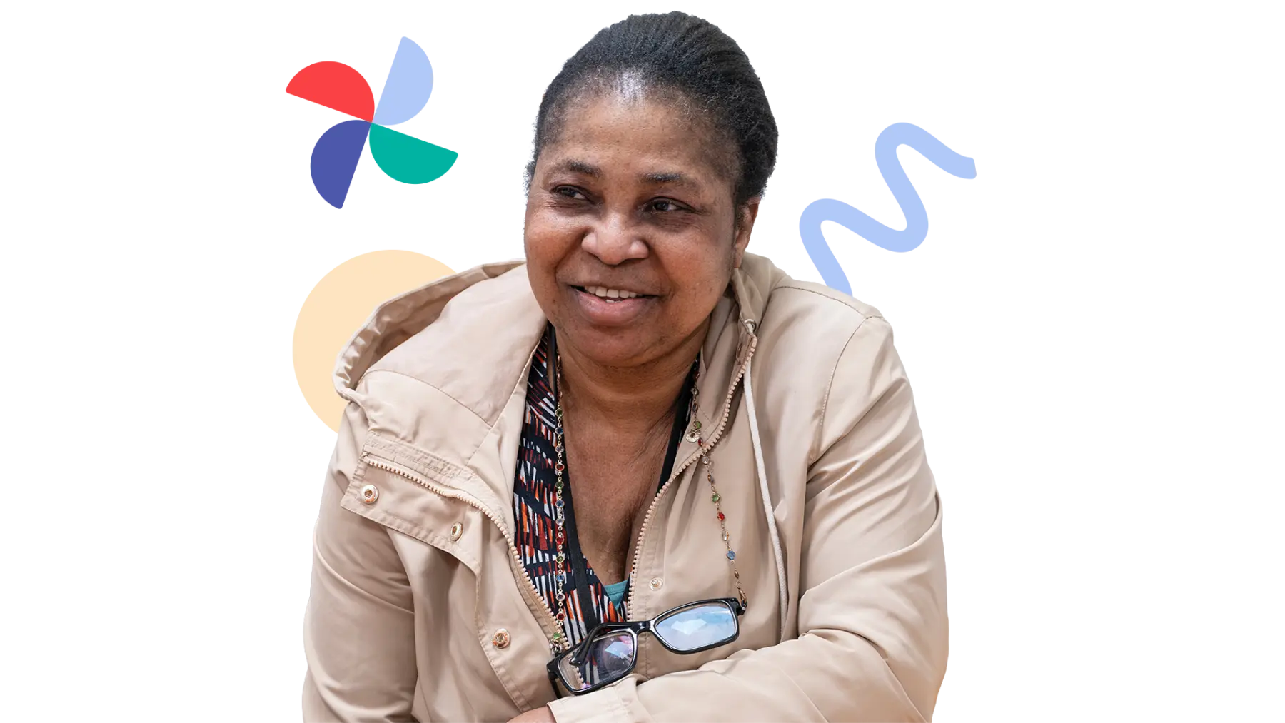 Image is of a person smiling while sitting with their arm on a table