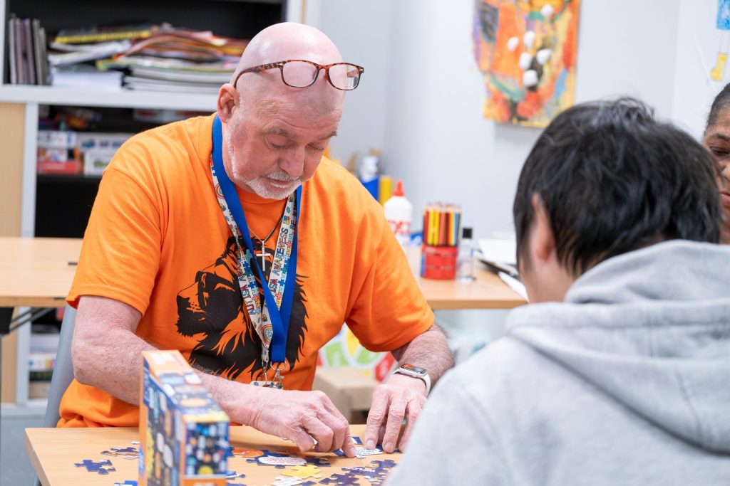 Two people do a jigsaw indoors