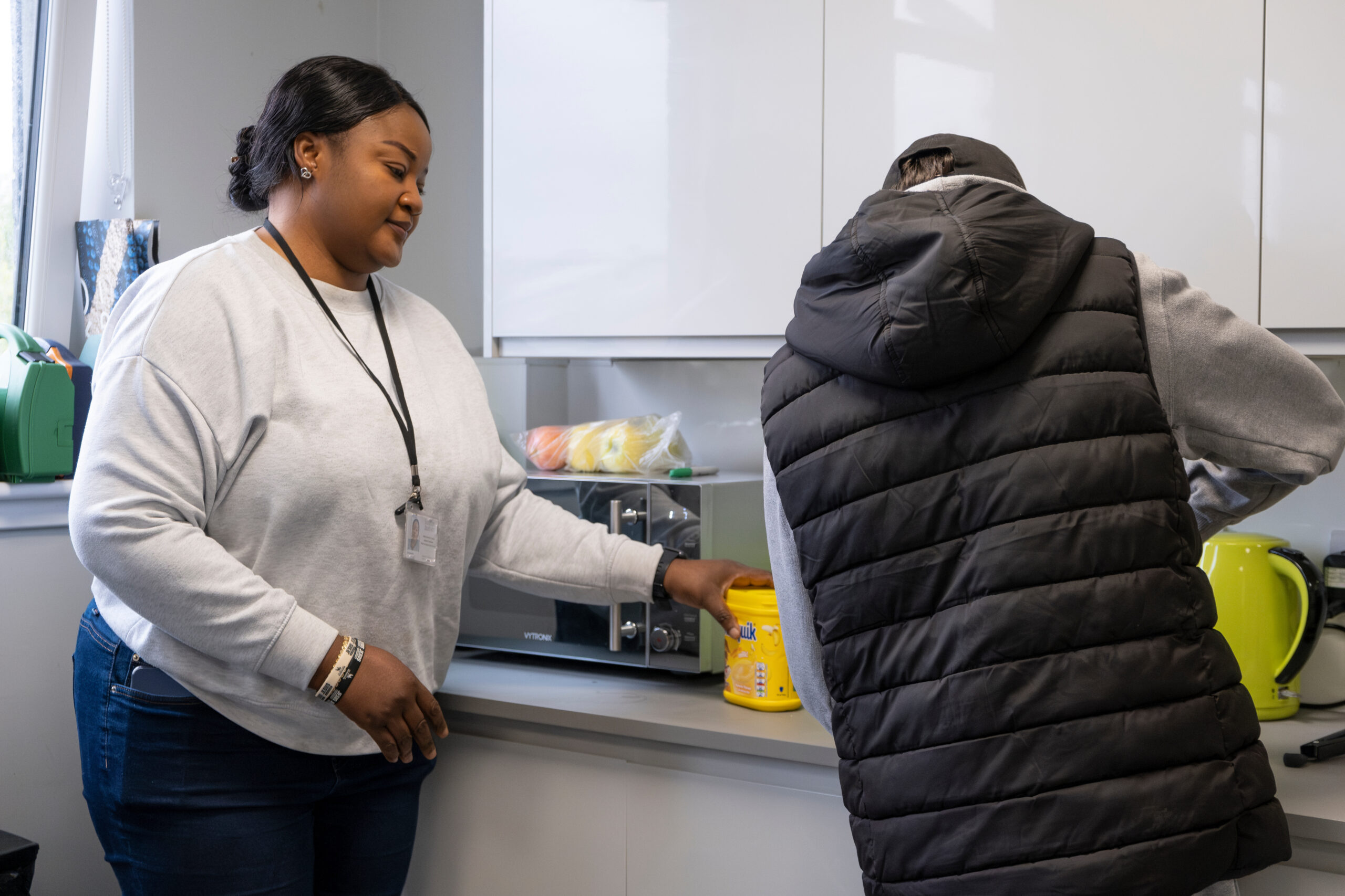 Image is of two people working together to make a meal, in a kitchen, an autism practitioner is supporting the other person