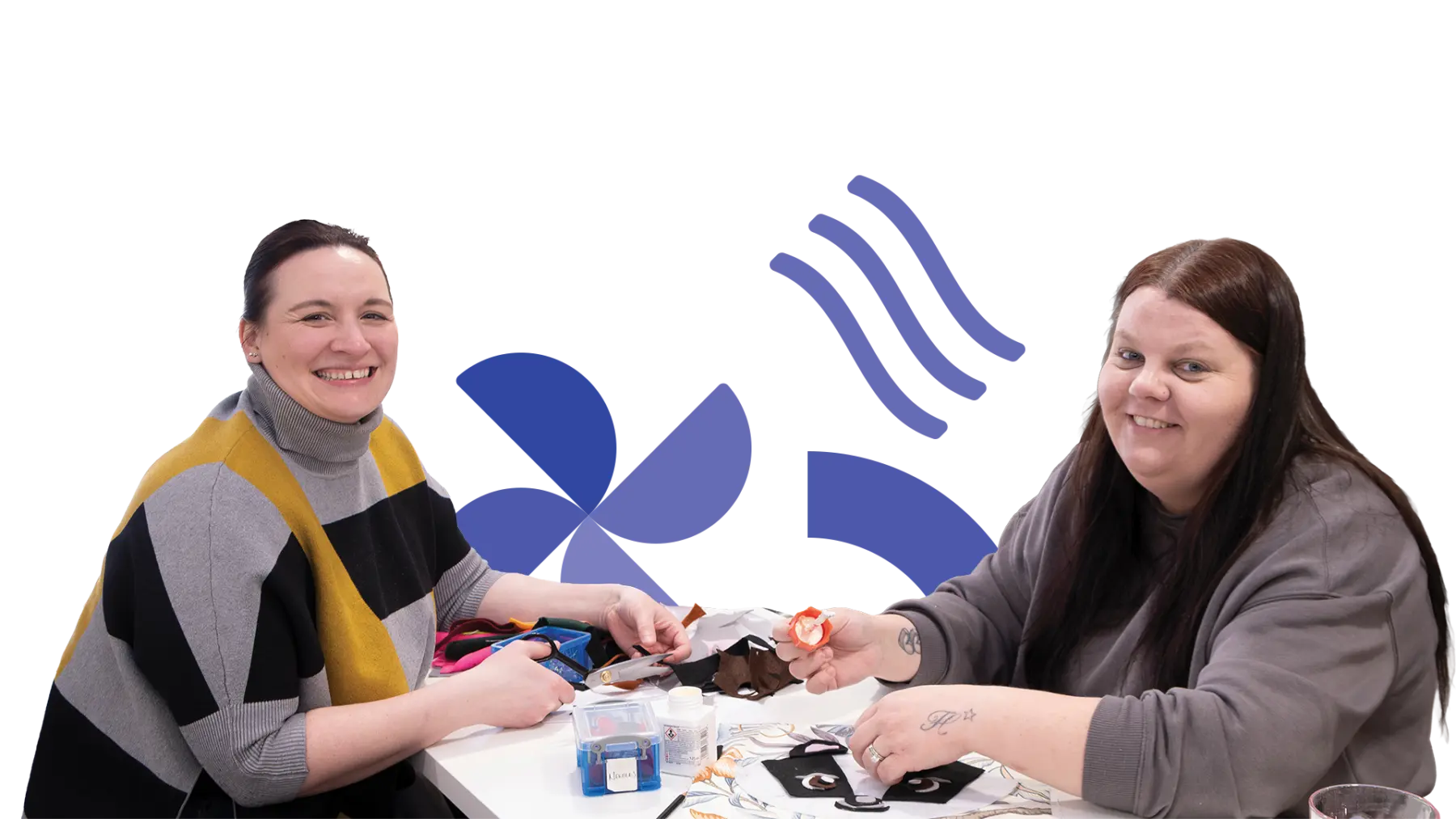 Image is of two people smiling for the camera while taking part in arts and crafts