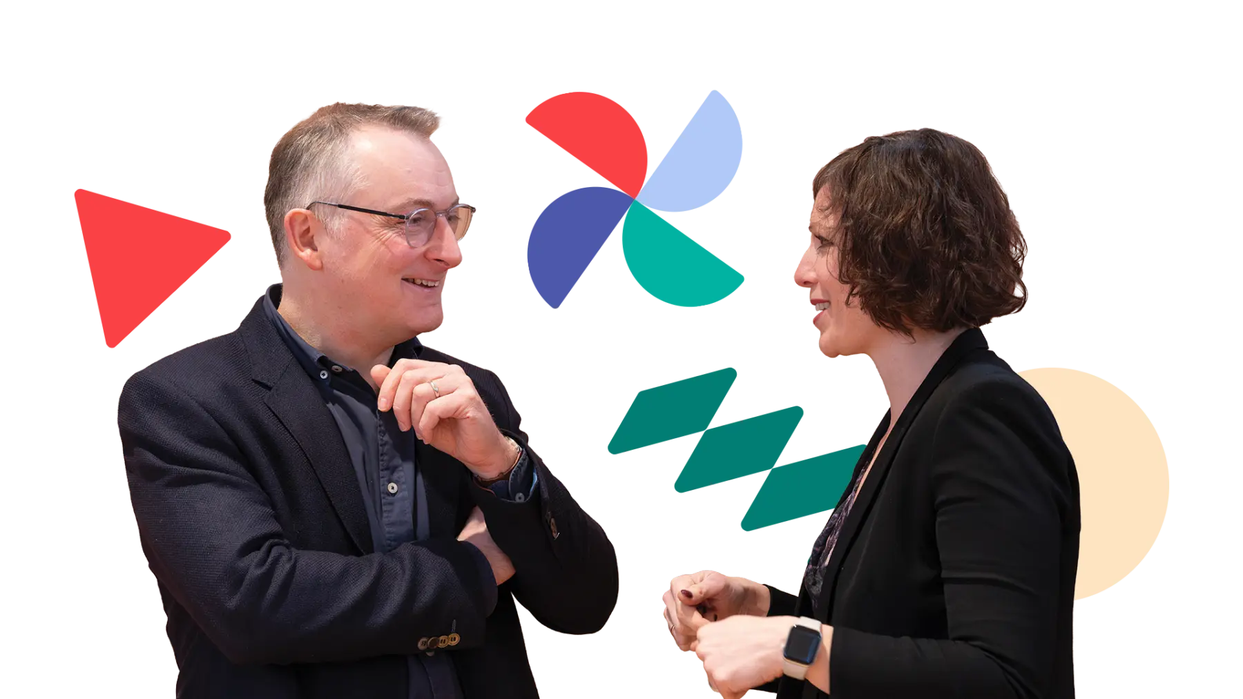 Image is of two people wearing suits, smiling and talking together