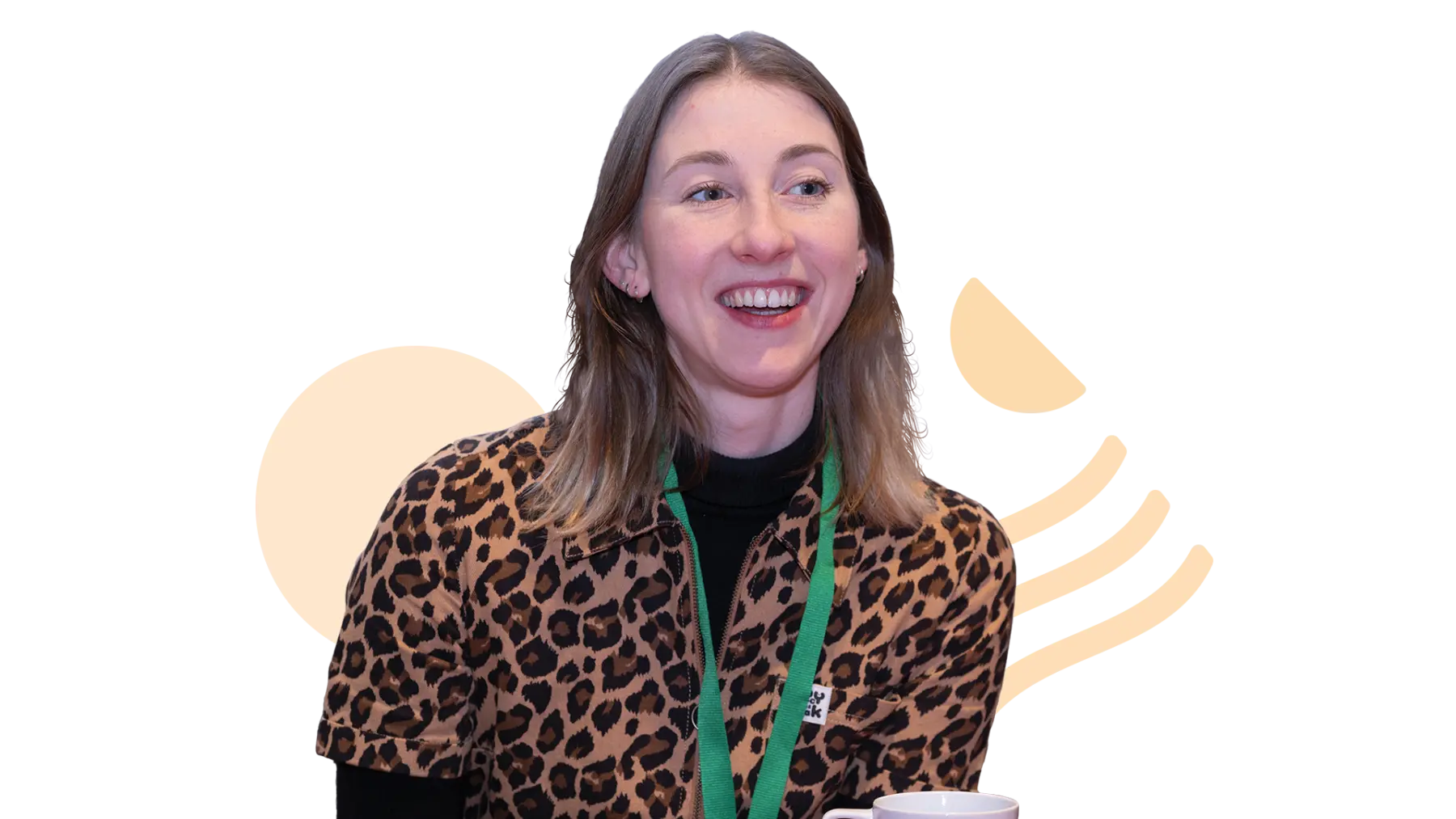 Image is of a person laughing and wearing a green lanyard