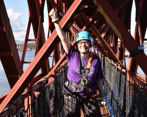 Image is of a Scottish Autism supporter in a harness, ready to take on an abseil
