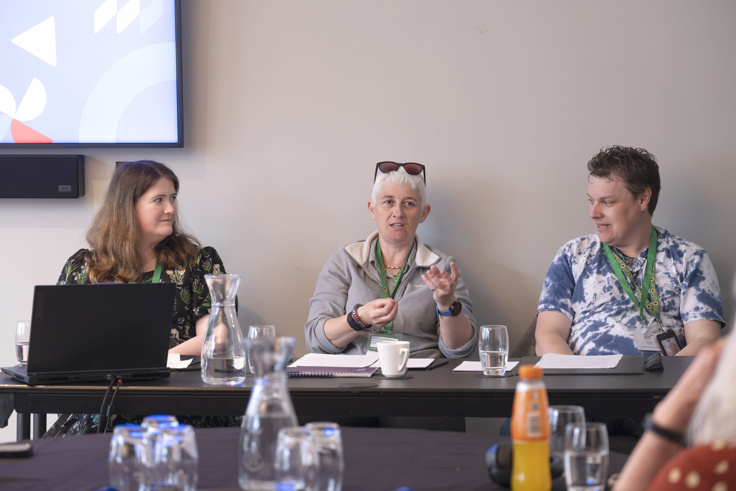 three people talking to a room of listeners