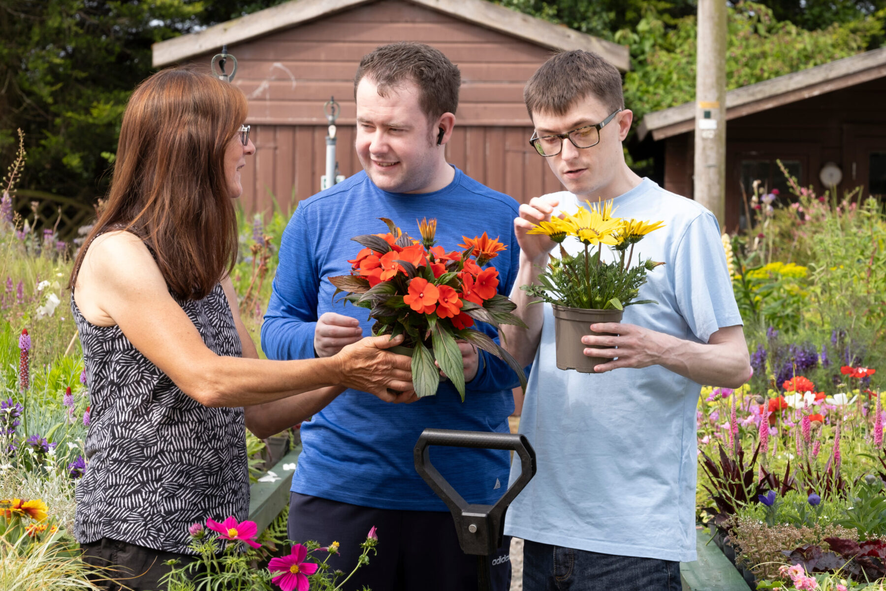 Image of three people chatting and holding flower pots